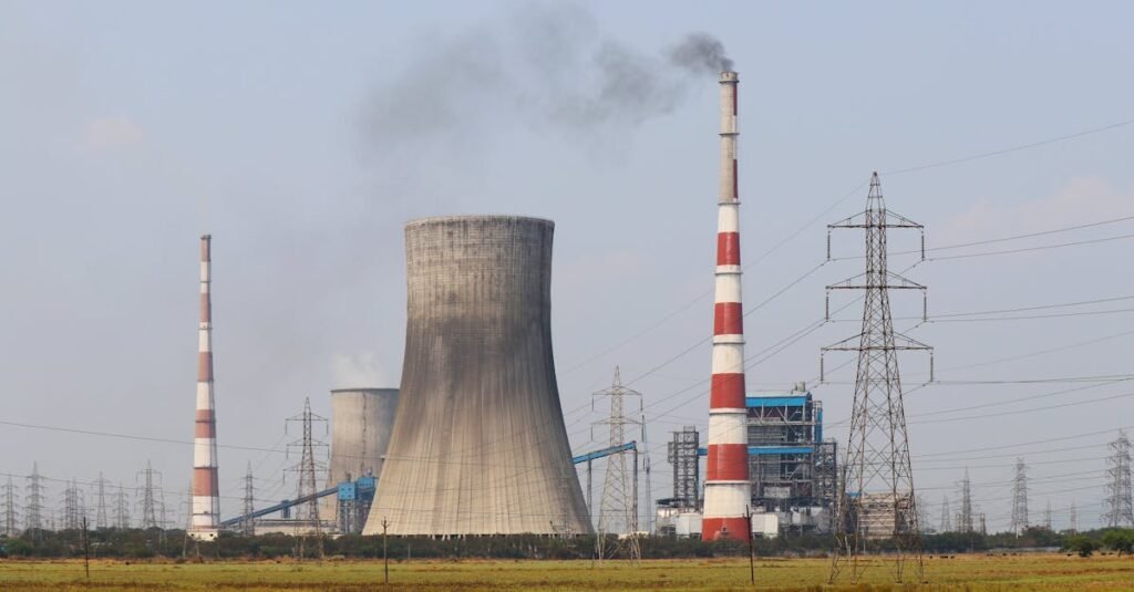 Smokestacks and a cooling tower emit smoke at a power plant in Vijayawada, India.